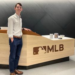 Josh Leeman standing in front of MLB desk