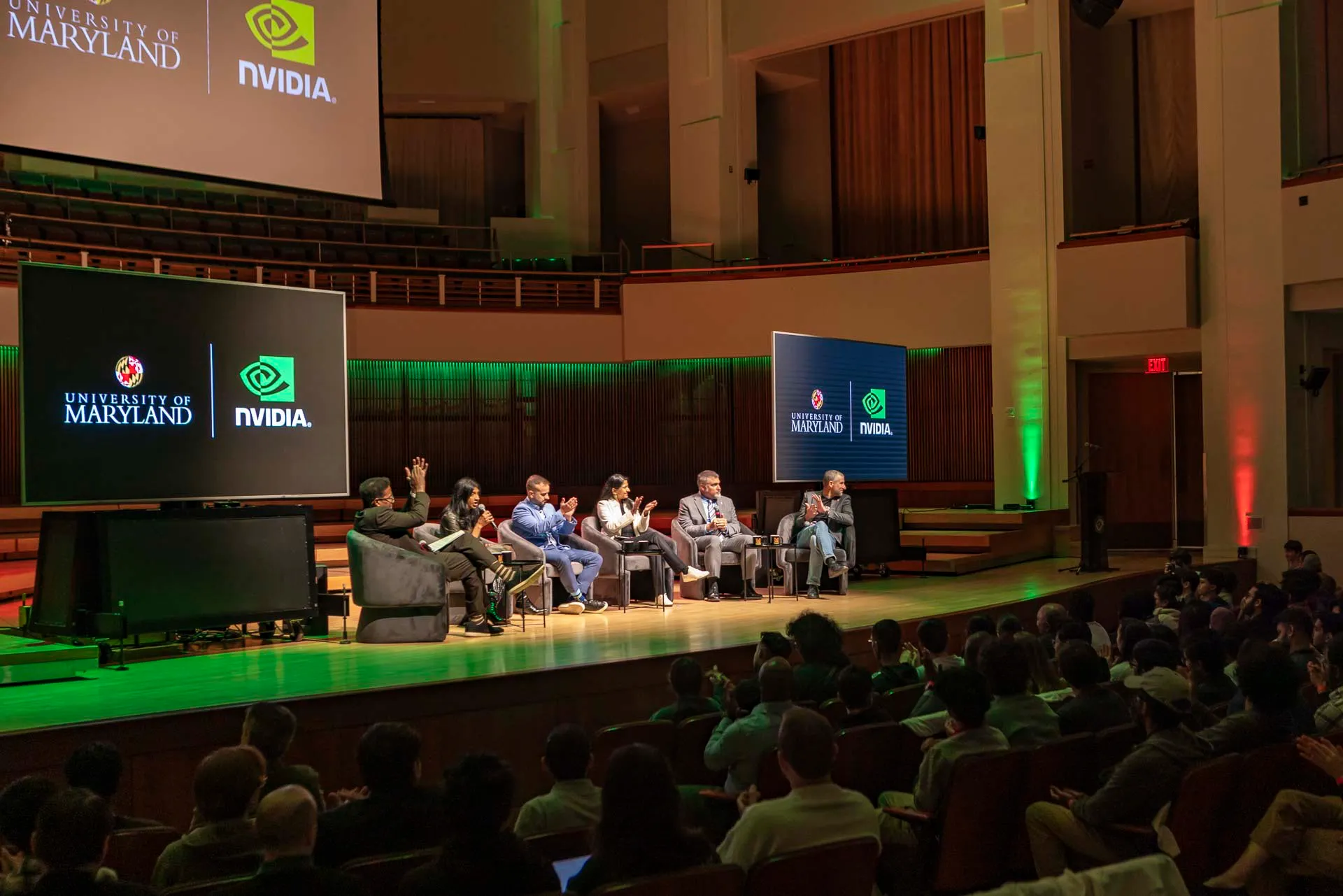 six panelists sit on stage