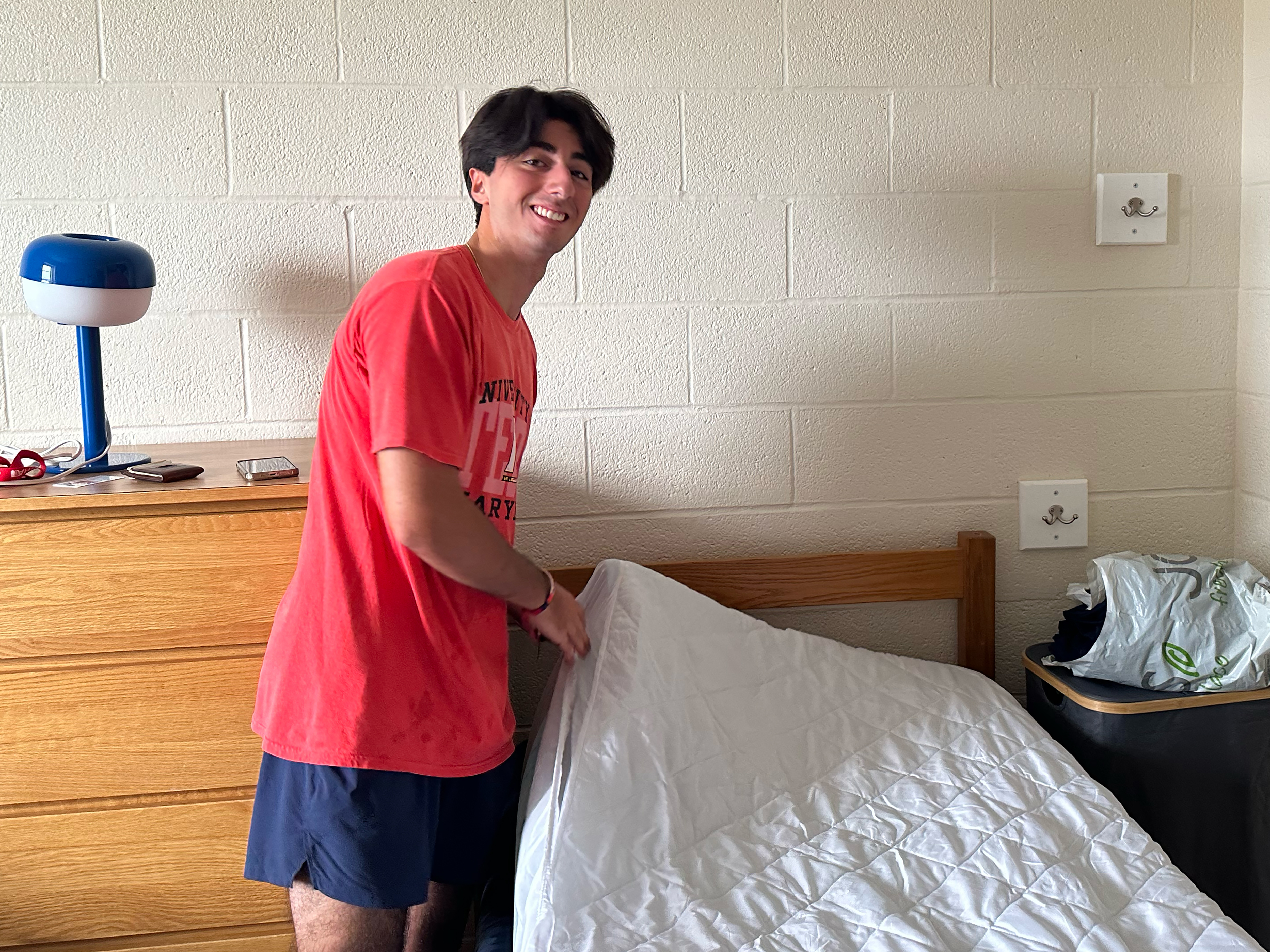 BioFIRE student making his bed in Easton Hall
