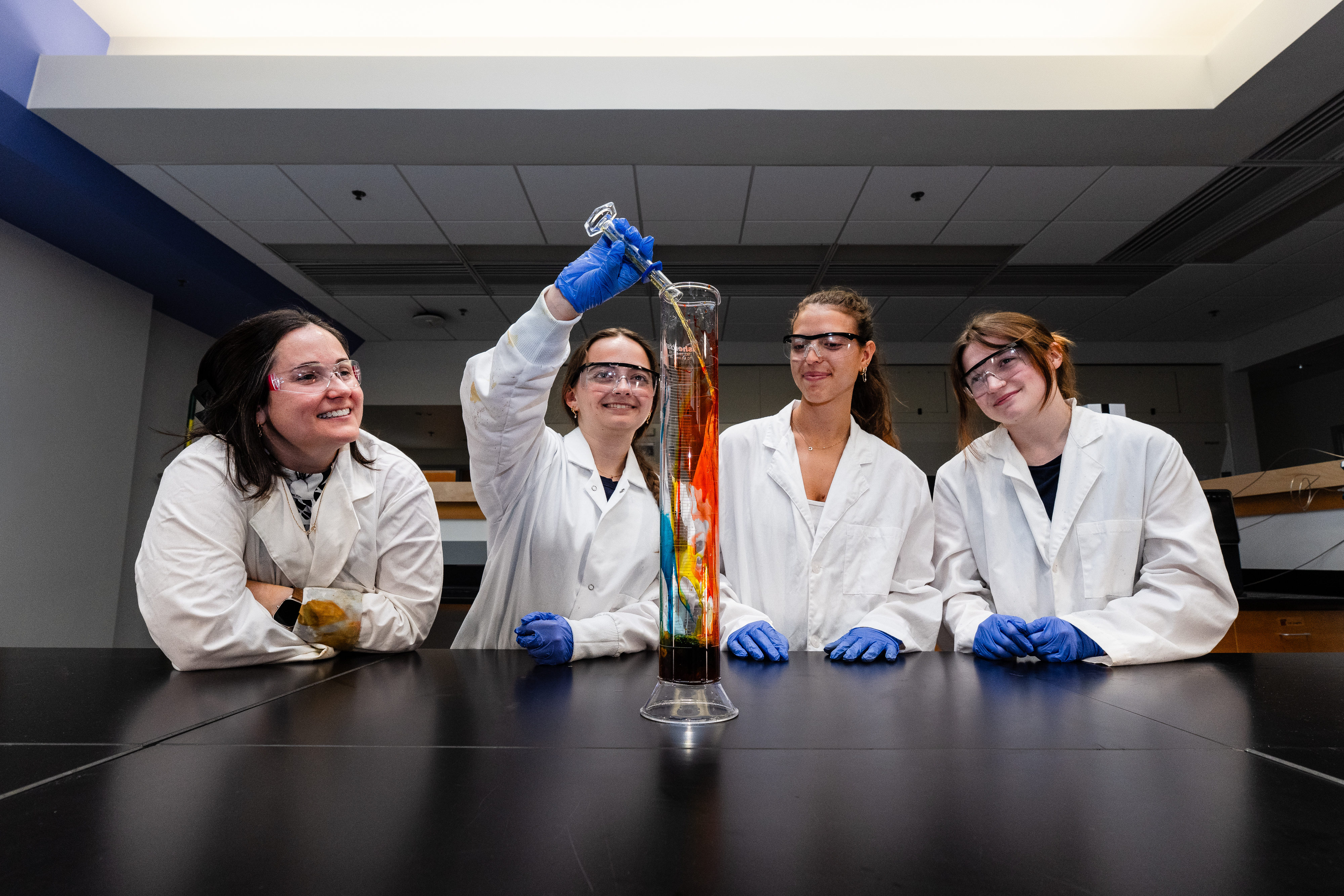 CHEM 316 students add chemicals to glass cylinder