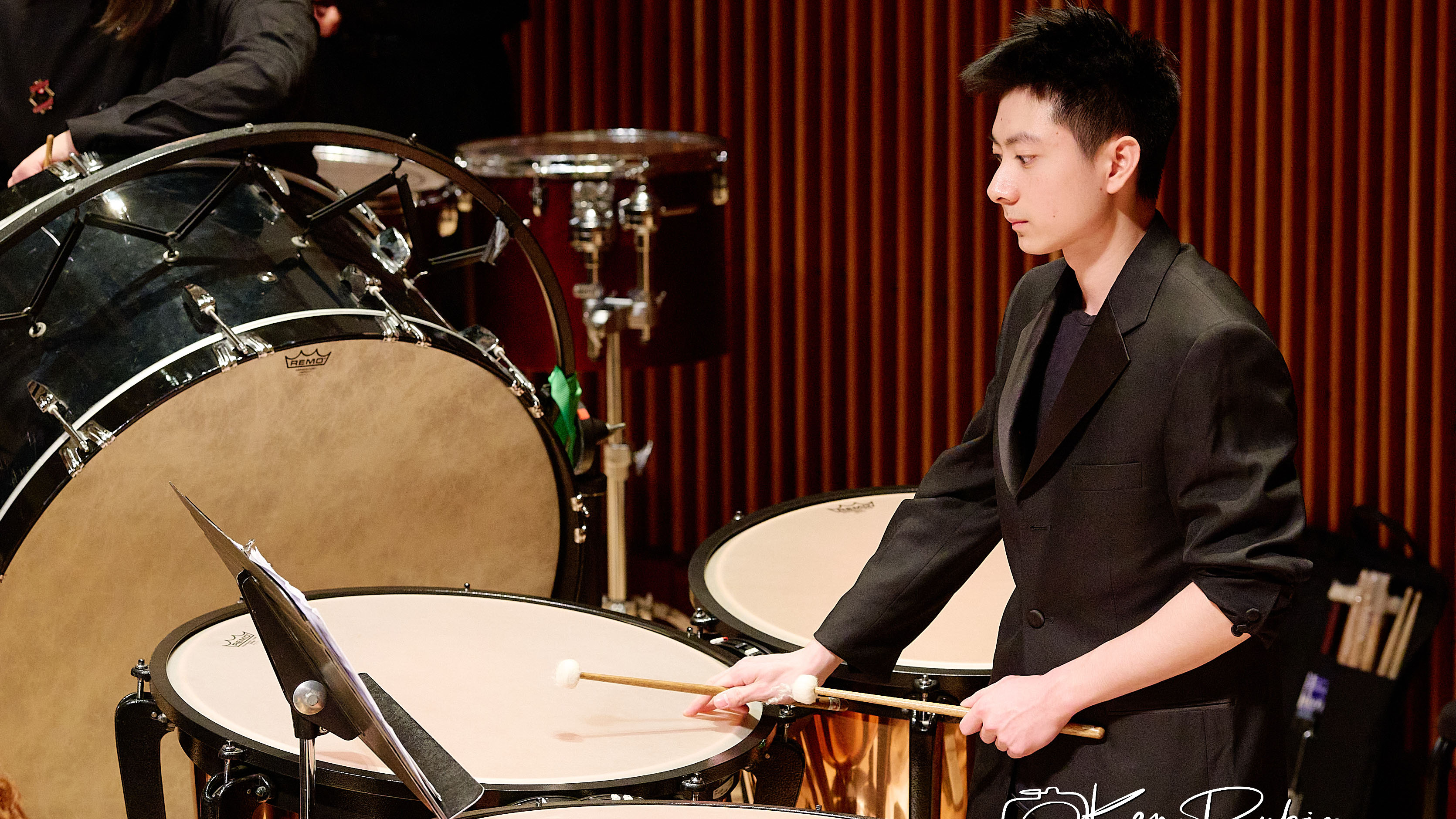 A male musician plays the drums.