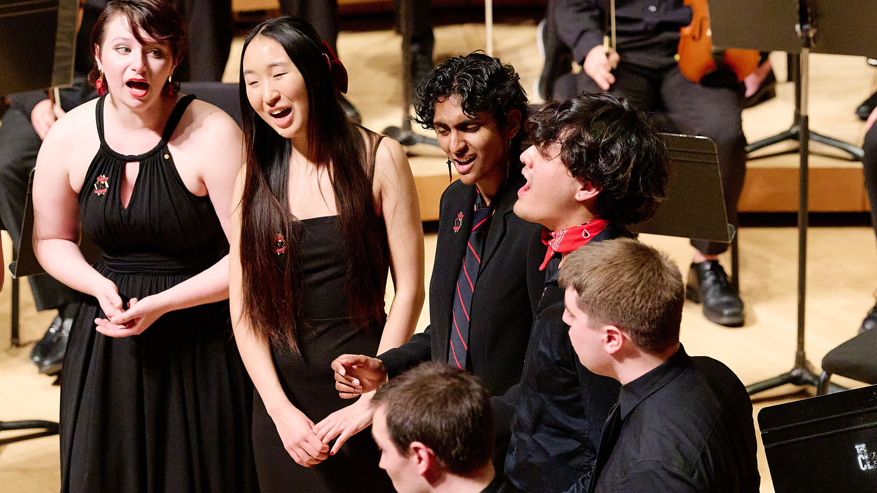 Singers standing on stage singing.