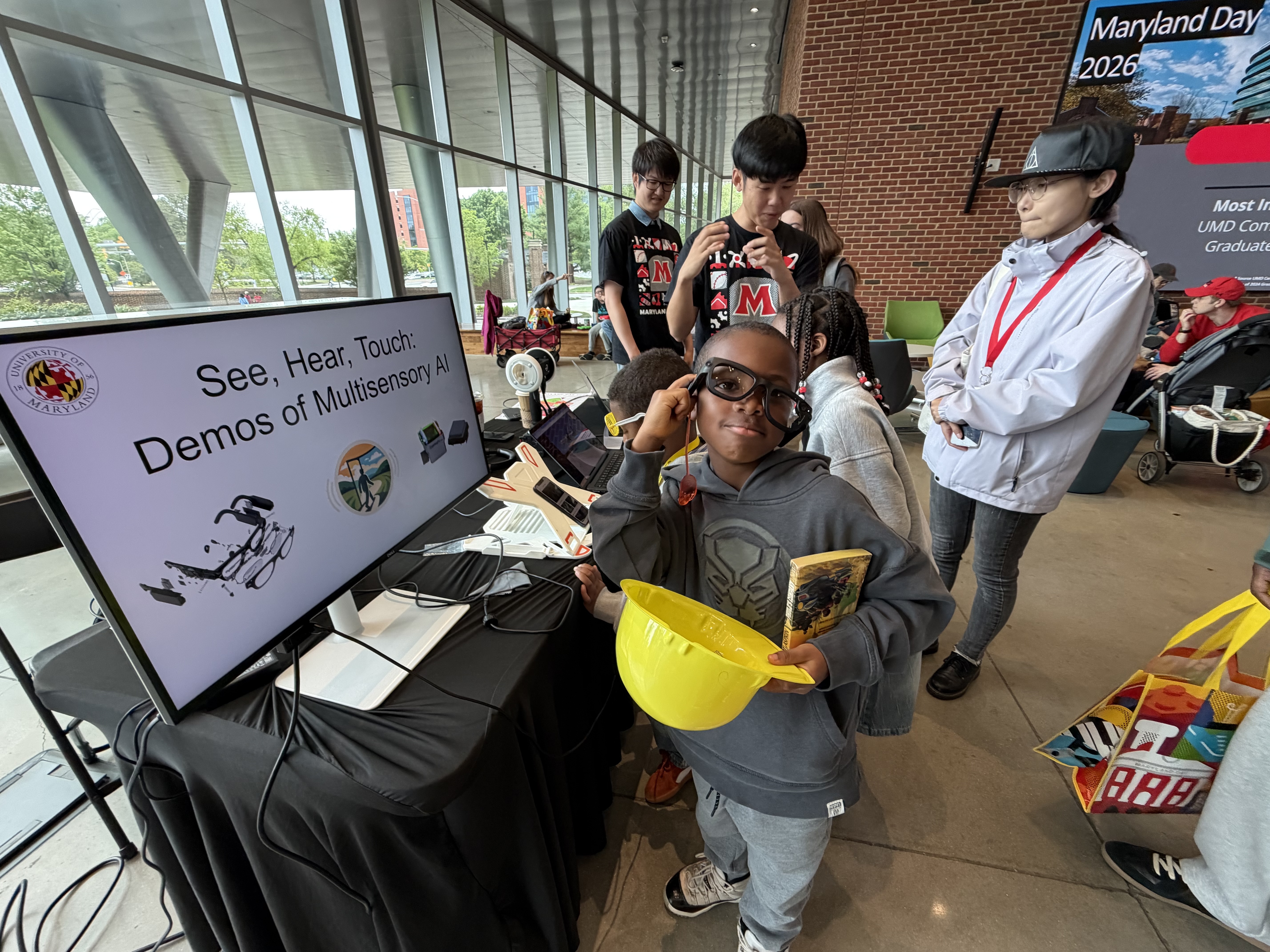Kids at Maryland Day 2026 in front of a computer screen with a demo of a new program called SonoWorld.