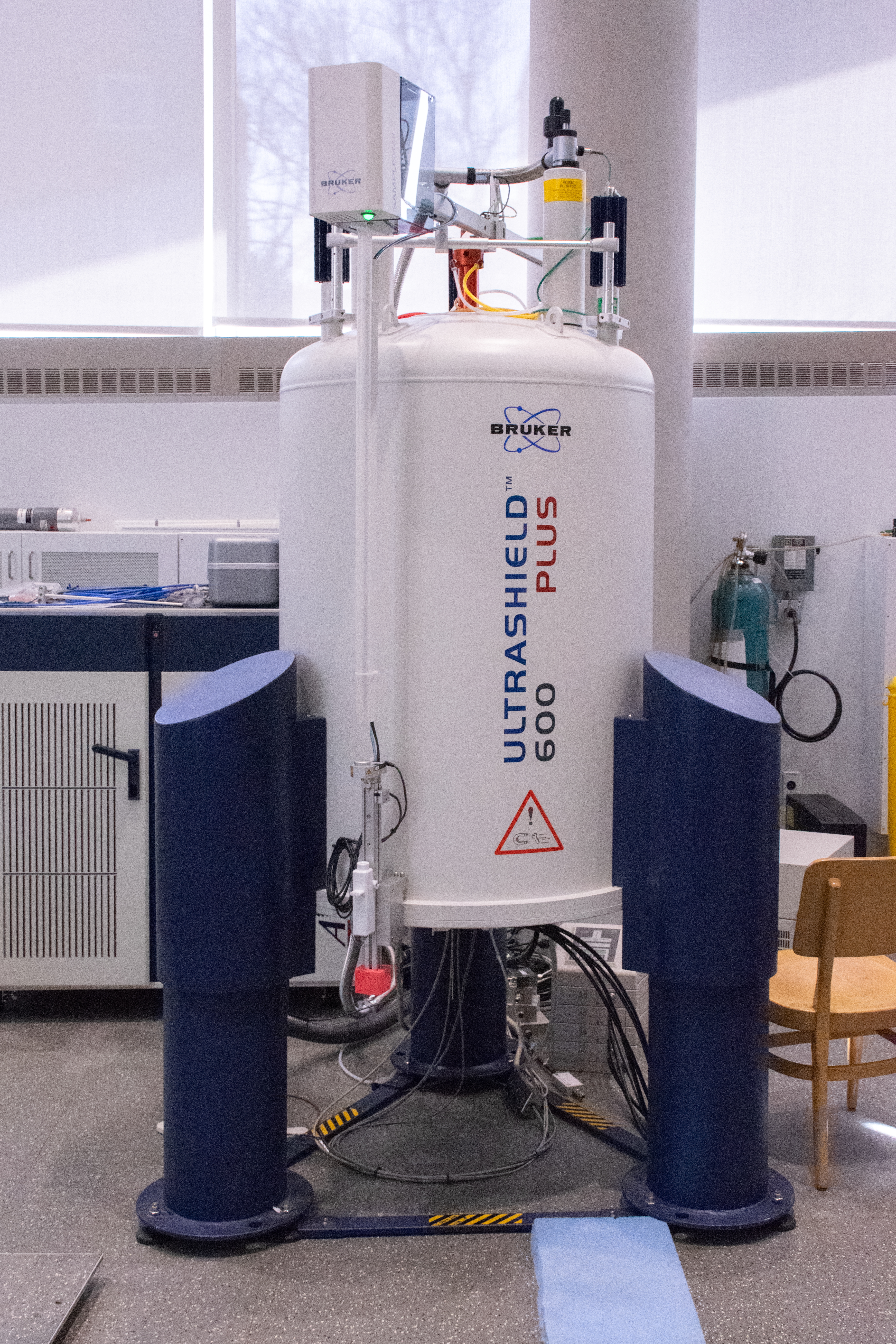 A Bruker 600 MHz NMR in a bright laboratory, surrounded by cables and equipment.