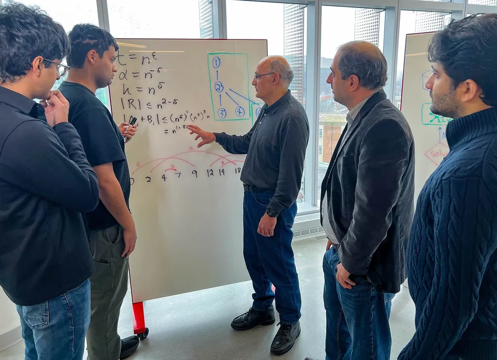 People stand around a whiteboard while a man points to equations
