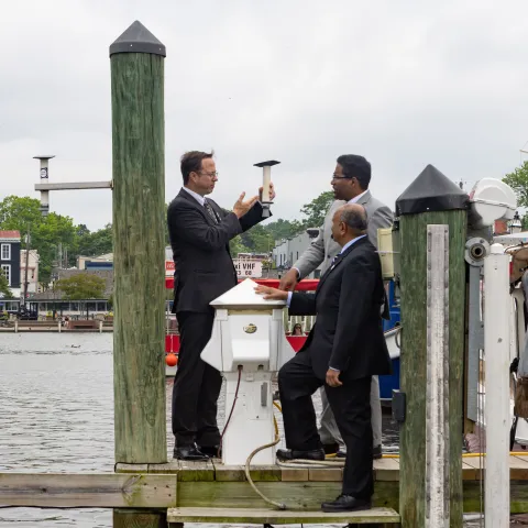 Three men standing on a dock in Annapolis