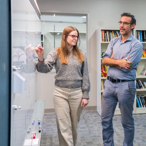 Two people standing at a whiteboard
