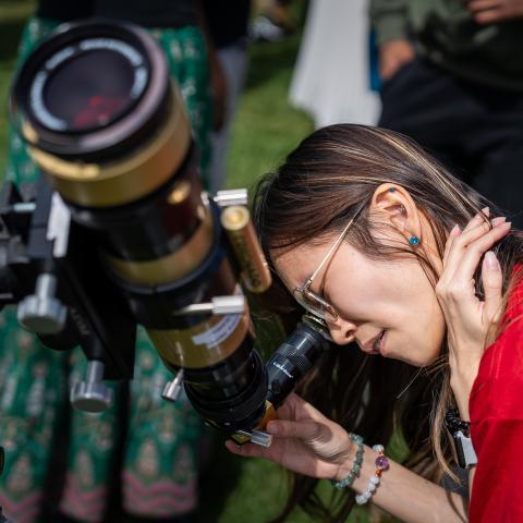 Woman looking through a telescope