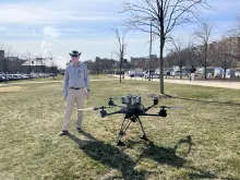 Daniel Lathrop standing next to a drone