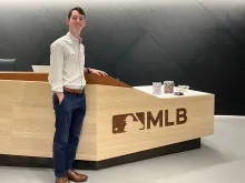Josh Leeman standing in front of MLB desk