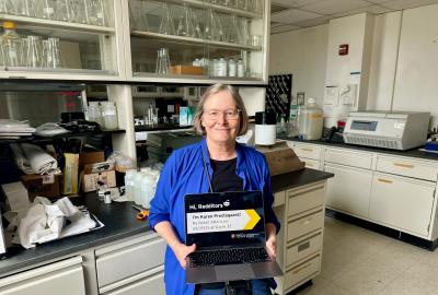 Karen Prestegaard holding a laptop in her lab