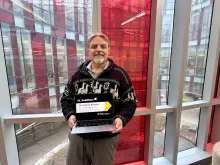 Alberto Bolatto holding a laptop in front of a window