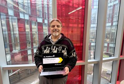 Alberto Bolatto holding a laptop in front of a window