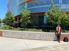 Fenil Gholani sitting in front of the Iribe Center in his graduation regalia