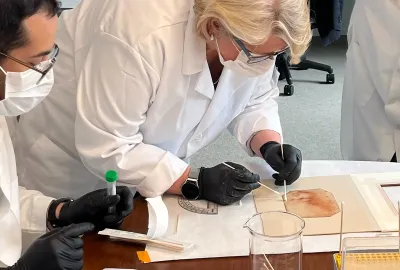 researcher in mask swabs back of "Holy Child"