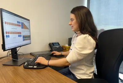 Sarah Wiegreffe sits at a computer, examining whether the reasoning processes used by advanced AI systems will remain transparent 