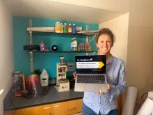 Megan Newcombe holding a laptop in her lab