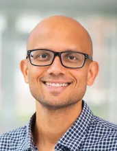 Pratyush Tiwary in glasses and a blue-checked shirt.