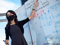 person pointing to a white board