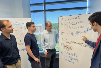 Team members working together by whiteboard