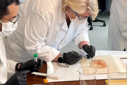 researcher in mask swabs back of "Holy Child"