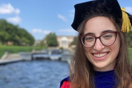 Jessica Kopew in her red UMD doctorate cap and gown.