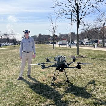 Daniel Lathrop standing next to a drone