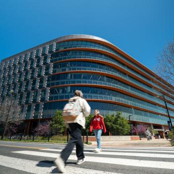 Exterior of Iribe Center building with people walking across the street