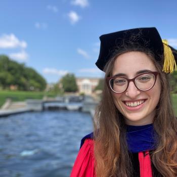 Jessica Kopew in her red UMD doctorate cap and gown.