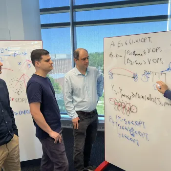 Team members working together by whiteboard