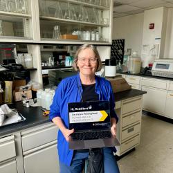 Karen Prestegaard holding a laptop in her lab