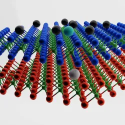 two layers of a chemical structure lie above each other with black balls hovering on top. On the top layer, there is a cyan ball with a white ball in the corresponding layer below