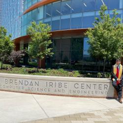 Fenil Gholani sitting in front of the Iribe Center in his graduation regalia