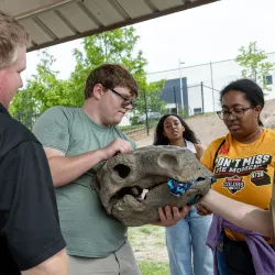 Liam Driver holding a model fossil head of a Priconodon