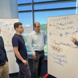 Team members working together by whiteboard