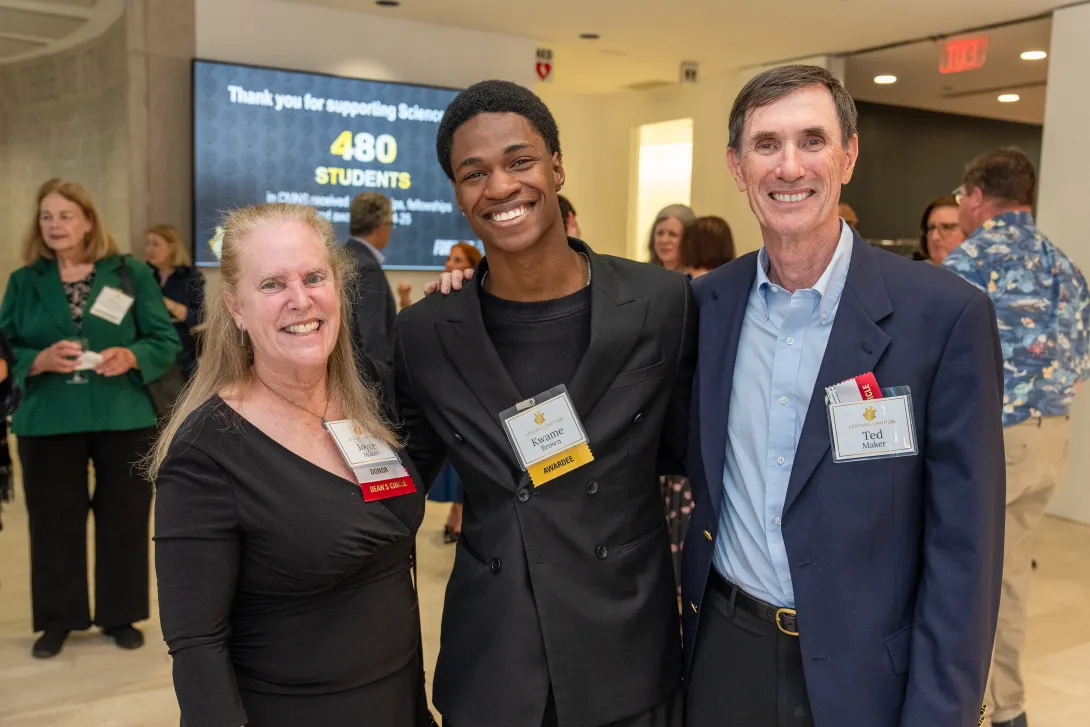 Three people standing together wearing nametags