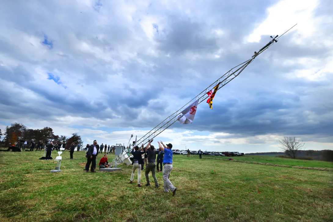 Group of people raising a Mesonet tower in a field