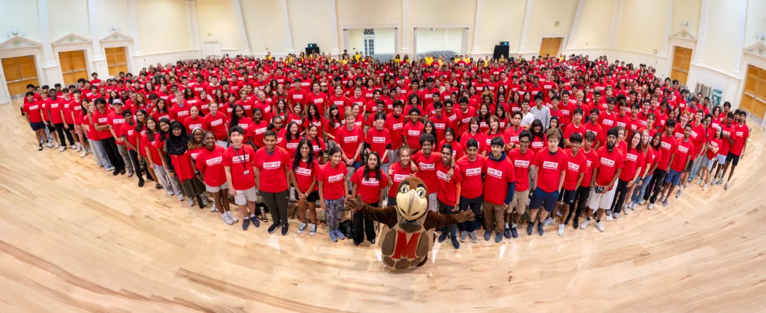 Group of people in red T-shirts with a terrapin mascot in front