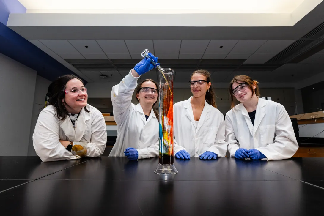 CHEM 316 students add chemicals to glass cylinder
